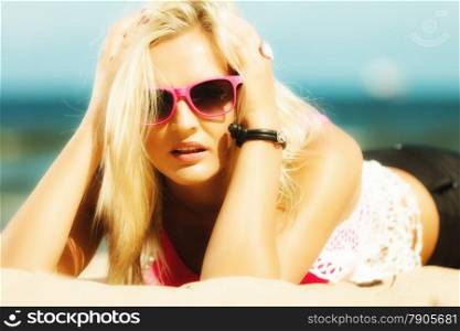 Holidays, vacation travel and freedom concept. Beautiful blonde girl laying on sandy beach, portrait
