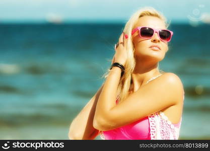 Holidays, vacation travel and freedom concept. Beautiful blonde girl laying on sandy beach, portrait