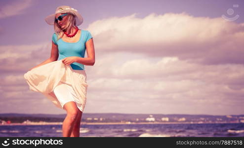 Holidays, vacation travel and freedom concept. Beautiful girl in summer clothing hat running on beach. Young woman having fun relaxing on the sea coast.