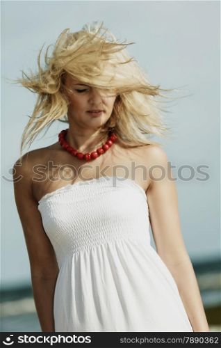 Holidays, vacation travel and freedom concept. Beautiful girl in white dress on beach. Lovely woman portrait outdoor, hair blowing on wind