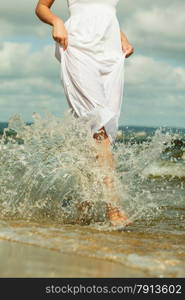 Holidays, vacation travel and freedom concept. Beautiful girl in white dress running on beach. Young woman having fun relaxing on the sea coast.