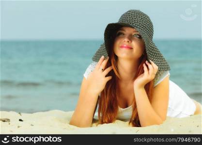 Holidays, vacation travel and freedom concept. Beautiful redhaired happy girl in hat on beach.