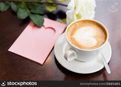 holidays, valentines day and love concept - close up of greeting card with heart, flower and coffee