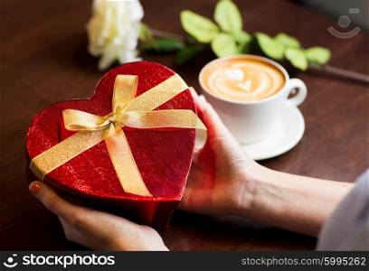holidays, valentines day, love and people concept - close up of hands holding heart shaped gift box