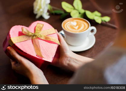 holidays, valentines day, love and people concept - close up of hands holding heart shaped gift box