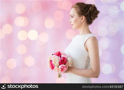 holidays, wedding and people concept - bride or woman in white dress with flower bunch over rose quartz and serenity lights background