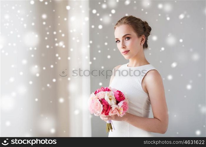 holidays, wedding and people concept - bride or woman in white dress with flower bunch over snow