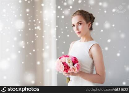 holidays, wedding and people concept - bride or woman in white dress with flower bunch over snow