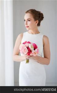 holidays, wedding and people concept - bride or woman in white dress with flower bunch
