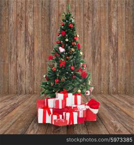 holidays, winter and celebration concept - christmas tree and presents over wooden room background