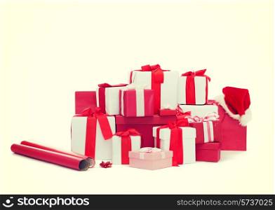holidays, winter, birthday and celebration concept - christmas presents, decoration paper and santa helper hat