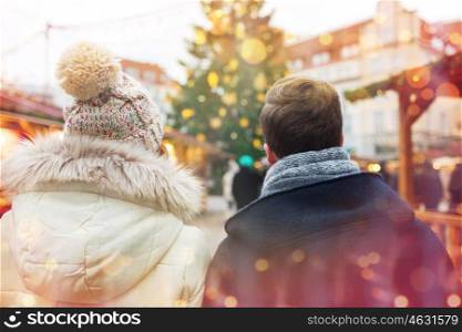 holidays, winter, christmas, tourism and people concept - close up of couple in old town from back over lights