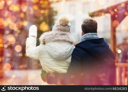 holidays, winter, christmas, tourism and people concept - close up of couple in old town from back over lights