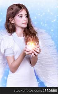 Holy angel, adorable girl with candle and wings on blue background, Christmastime holidays, dreaming and praying concept