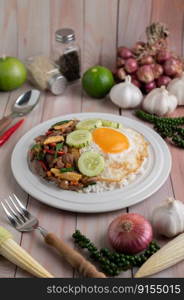 Holy Basil Fried Rice with Chicken Heart and Fried Egg on a White Wooden Floor.