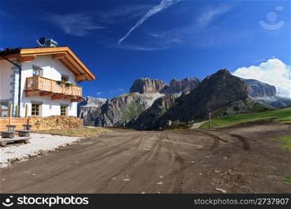 home and dirt road on Dolomites mountain, Italy