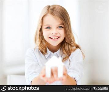 home and family concept - little girl holding white paper house