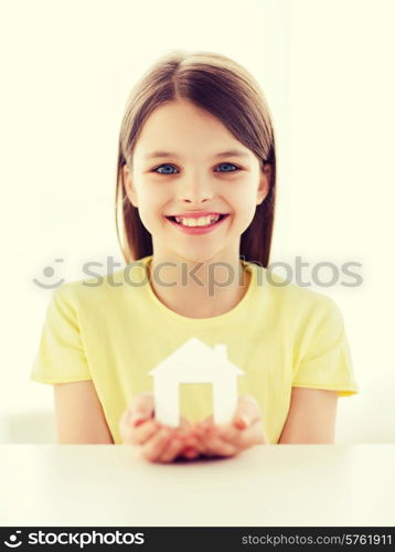 home and family concept - little girl holding white paper house