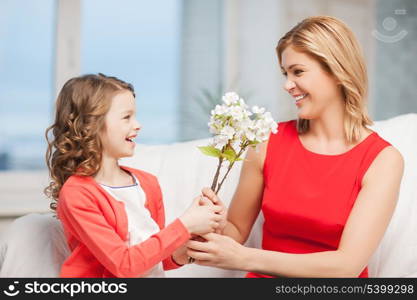 home and family - happy mother and daughter with flowers