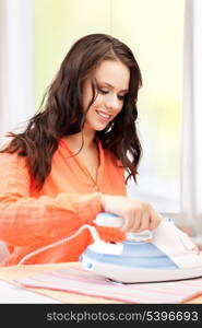 home and housework concept - perfect housewife ironing clothes.