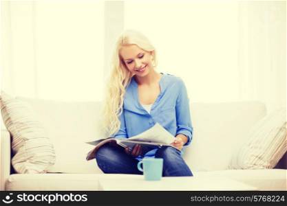 home and leasure concept - smiling woman sitting on couch and reading magazine at home
