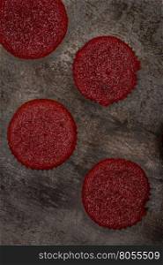 Home baked red beetroot muffins on dark metal textured background.