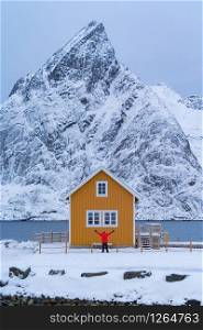 Home, cabin or house, Norwegian fishing village in Reine City, Lofoten islands, Nordland county, Norway, Europe. White snowy mountain hills, nature landscape background in winter season.