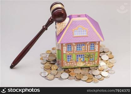 Home, coins and gavel isolated on gray.Real estate concept