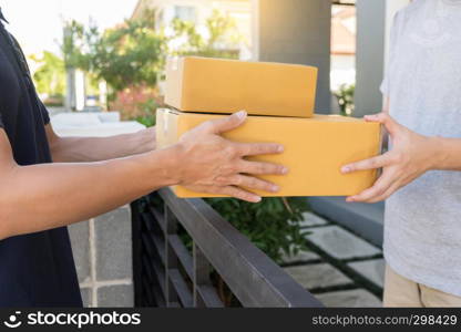 Home delivery service delivers package at home and woman receiving by signing for online shopping order