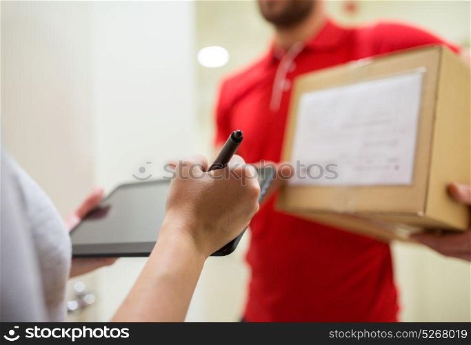 home delivery service, mail, people and shipping concept - woman customer with tablet pc computer signing for parcel box. customer with tablet pc signing for parcel