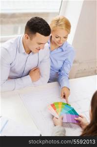 home, design and architecture concept - smiling couple looking at blueprint and color samples at office