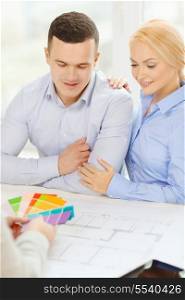 home, designe and architecture concept - smiling couple looking at blueprint and color samples at office