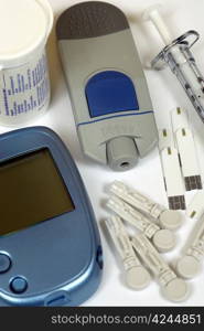 Home Diabetes self-test kit including glucose test strips, sharp lancets, syringe, and glucometer.