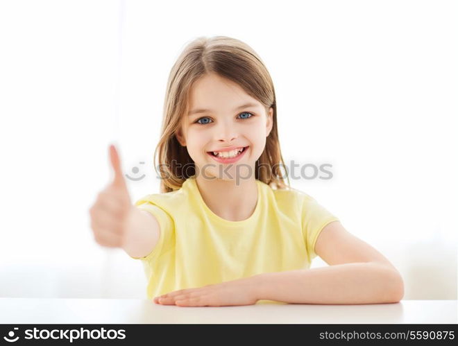 home, education, happiness and people concept - beautiful little girl at home showing thumbs up