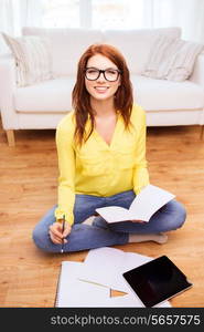 home, education, technology and people concept - smiling teenage girl sitting on the floor with tablet pc computer and workbook at home