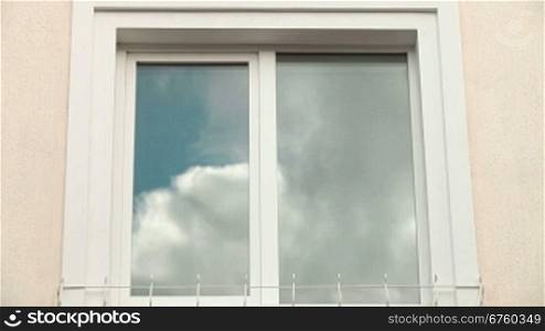 Home Exterior With Cloud Reflection In Plastic Window Frame