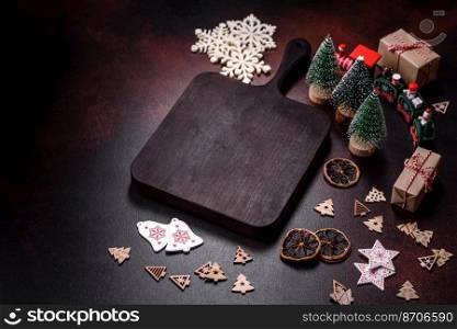 Home festive Christmas table decorated by toys and gingerbreads on a dark concrete background. Home festive Christmas table decorated by toys and gingerbreads