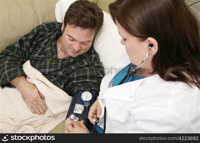 Home health nurse taking her patient&rsquo;s blood pressure.