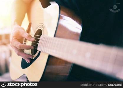 Home hobbies concept, Man hands playing acoustic guitar, close up guitar player Musical instrument for recreation or hobby passion