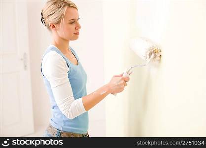 Home improvement - handywoman painting wall with roller