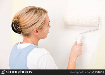 Home improvement - handywoman painting wall with roller