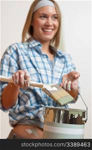 Home improvement: Smiling woman holding paint can and brush