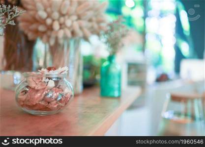 Home interior decor dried flowers in glass vase in Living room decoration. rustic brown wooden table restaurant cafe interior.