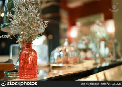 Home interior decor dried flowers in glass vase in Living room decoration. rustic brown wooden table restaurant cafe interior.