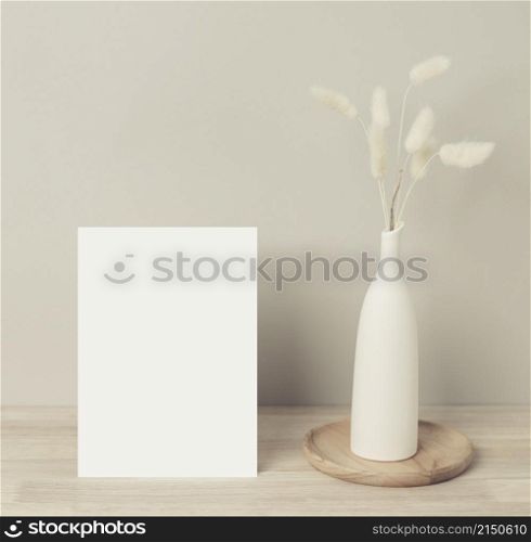 Home interior floral decor, pampas grass on table, Front view, blank paper card, Greeting card Mockup. Beautiful white pampas grass in vase on wood background