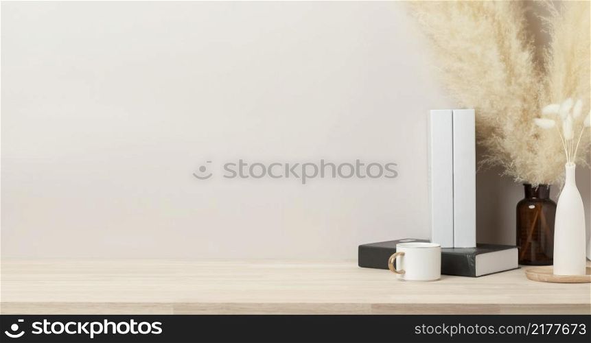 Home interior with decoration dried Bunny Tail and pampas grass, Front view, Beautiful pampas grass in vase and white book on wood table and beige cement wall background