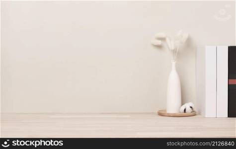 Home interior with decoration dried Bunny Tail grass, Front view, Beautiful Bunny Tail grass in vase and white book on wood table and beige cement wall background