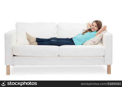 home, leisure and happiness concept - smiling little girl lying on sofa