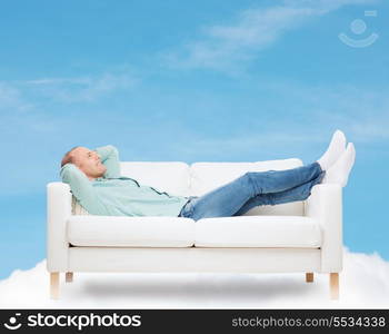 home, leisure and happiness concept - smiling man lying on sofa