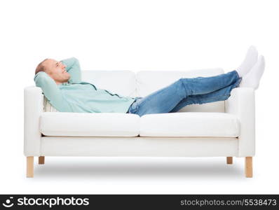 home, leisure and happiness concept - smiling man lying on sofa